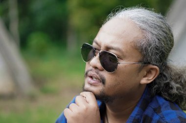 Kıvırcık saçlı adam orman kulübesinde kamp yapmaya gidiyor. Seyahat konsepti..