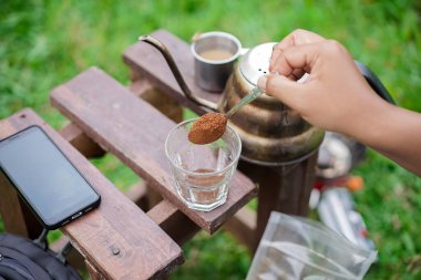 Ormanda kamp yaparken kahve yapan bir adam. Seyahat kavramı..