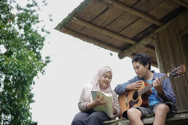 Endonezyalı genç adam ve kadın tesettüre girmişler. Birlikte orman kulübesinde dinleniyorlar. Gitar çalıyorlar ve kitap okuyorlar..