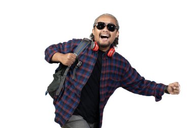 Kıvırcık saçlı Endonezyalı erkek sırt çantalı. Beyaz arka planda izole edilmiş seyahat, seyahat konseptini yakalamak için acele ediyor..