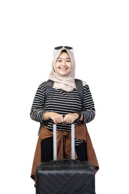 Genç Endonezyalı kadın tesettürcü seyahat etmek için heyecanlı bavul, seyahat konsepti, beyaz arka planda izole edilmiş.