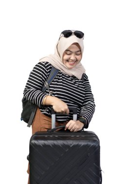 Genç Endonezyalı kadın tesettürcü seyahat etmek için heyecanlı bavul, seyahat konsepti, beyaz arka planda izole edilmiş.