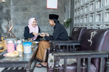 Lebaran 'da ketupat ve opor ayam yiyen genç bir çift. Lebaran konsepti. Müslüman bir aile. Lebaran mevsimi.