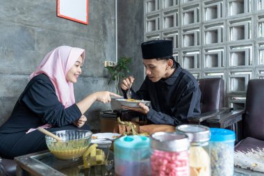 Lebaran 'da ketupat ve opor ayam yiyen genç bir çift. Lebaran konsepti. Müslüman bir aile. Lebaran mevsimi.