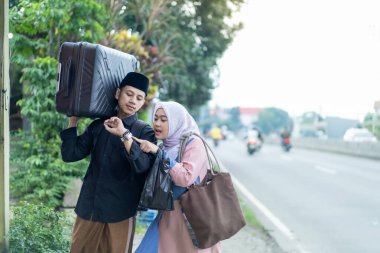 Bavullu Asyalı Müslüman çift gitmeye hazırlanıyor. Bayram kutlaması için seyahat eden kadın ve erkek konsepti