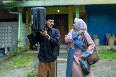 Bavullu Asyalı Müslüman çift gitmeye hazırlanıyor. Bayram kutlaması için seyahat eden kadın ve erkek konsepti