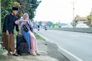 Bavullu Asyalı Müslüman çift gitmeye hazırlanıyor. Bayram kutlaması için seyahat eden kadın ve erkek konsepti