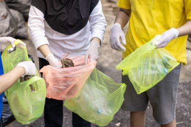 Çöp toplama. Plastik atıkları ayıran ellere yakın durun. Çöplerle ilgilenen birkaç kişinin elleri..