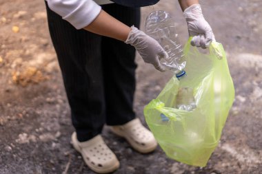 Çöp toplama. Plastik atıkları ayıran ellere yakın durun. Çöplerle ilgilenen birkaç kişinin elleri..