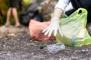 Çöp toplama. Plastik atıkları ayıran ellere yakın durun. Çöplerle ilgilenen birkaç kişinin elleri..