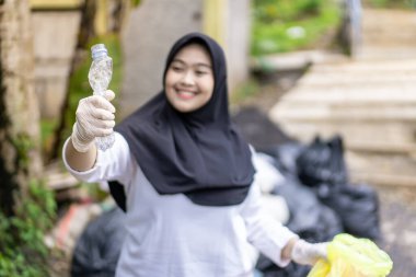Çöp toplama. Plastik atıkları sınıflandıran bir kız. Çöplerle ilgilenen tesettürlü kız..