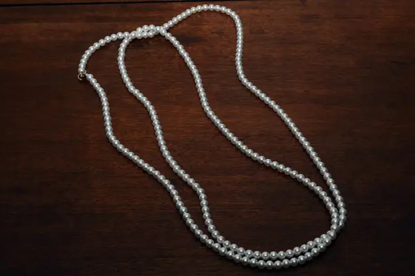 Ahşap arka planda inci kolye.