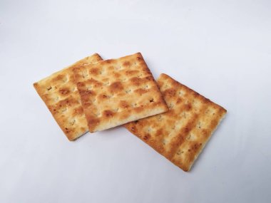 Beyaz arka plan üzerine şeker serpiştirilmiş bisküviler..