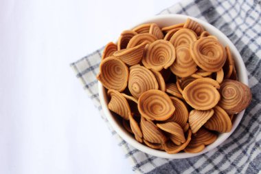 Kue kuping gajah. Fil kulaklı kek, Endonezya 'dan geleneksel bir aperatif izole bir arka planda bir kasede servis edilir..