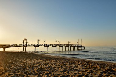 Gün doğumunda Marbella plaj kulübünde ahşap iskele.