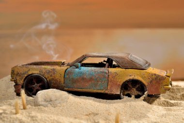 Oyuncak spor arabanın motor dumanıyla kumsala sıkışmış hali.