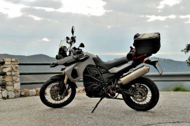 Dağlardaki yolda sırt çantalı siyah bir bisiklet.