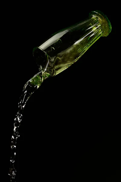 water falling from the glass to the ground with black background for advertising