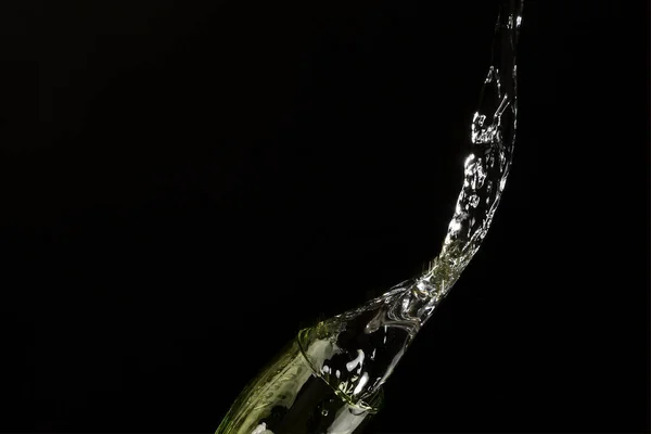 water falling from the glass to the ground with black background for advertising