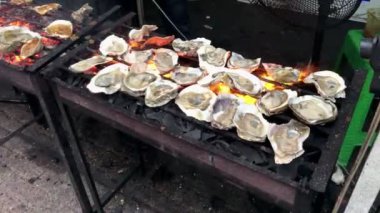 Kuzey Pasifik Okyanusu 'ndan taze istiridye ve Endonezya' dan Padang baharat sosu ızgarada kızartılıyor.