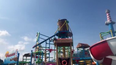 Water playground in swimming pool water park at summer vacation time in the morning with a bright blue sky as a background. Jakarta, August 06, 2024