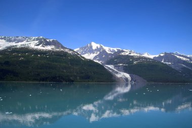 Mountain range reflected in College Fjord the northern sector of Prince William Sound, Alaska  clipart