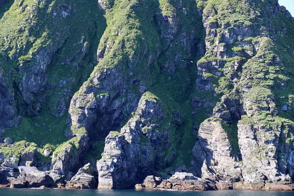 stock image View of the island Hjelmsoya with the large bird rock called Hjelmsoystauren, Norway  