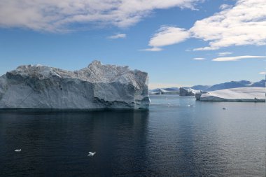 Arctic, icebergs in sunshine in Uummannaq Fjord, Greenland, Denmark clipart