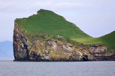 Lonely house on the Icelandic island of Ellidaey in the Vestmannaeyjar archipelago clipart