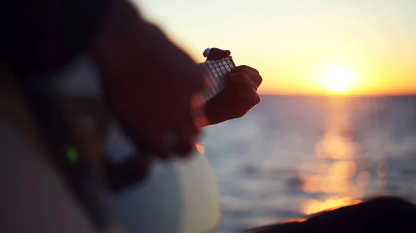 Adam açık havada gitar çalıyor