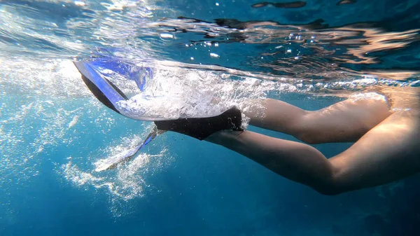 Swimming with fins. Girl is swimming, underwater shot