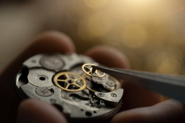 Saatin kadranını inceleyen bir saatçinin siyah beyaz yakın plan fotoğrafı.