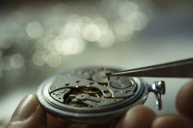 Saatçi klasik mekanik saat hareketini tamir ediyor