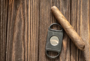 Bir bardak buzlu viski ve ahşap masada puro, yakın plan.