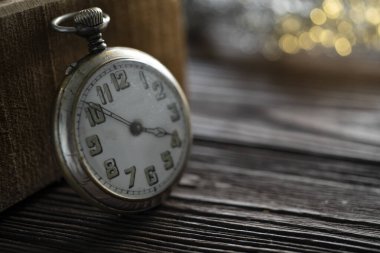 Ahşap arka planda klasik gümüş cep saati