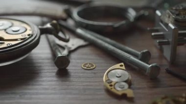 Eski parçalanmış mekanik kol saati. Bir saat atölyesindeki eski mekanik saatin metal parçaları. Sinema 4K 60fps video