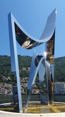 Como, İtalya 'daki Life Electric anıtı (Haziran 2023). Paslanmaz çelik çağdaş sanat abidesi, Como Gölü 'nün kıyısındaki bir rıhtımda bulunan fizikçi Alessandro Volta' ya ithaf edilmiştir.).