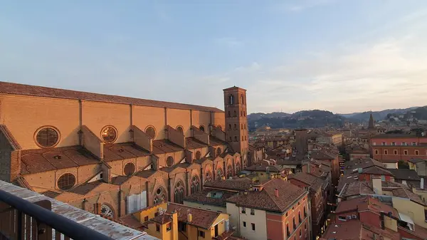 San Petronio Bazilikası ön cephesi ve tuğla çatılar Bologna (İtalya) üzerinde Şubat 2023, gün batımında.