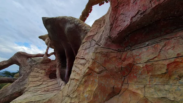 Gürcistan 'ın Tiflis kentindeki Mtatsminda Parkı' nda (Nisan 2023) soyut kestane taşı heykeli. Çatlaklı taş duvar, ağaç köklerine benzeyen şekiller..