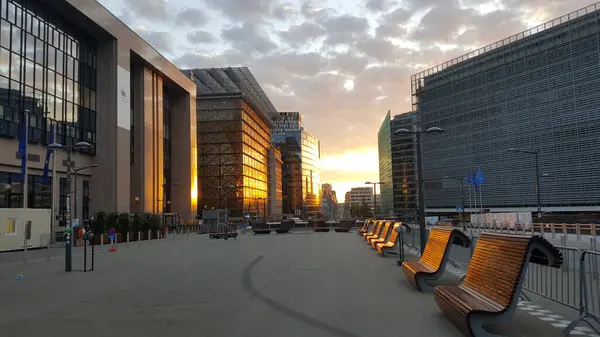 Robert Schuman Meydanı yakınlarındaki Brüksel 'in AB semtinde yaz günbatımı. AB Konseyi 'nin Justus Lipsius ve Europa binaları üzerinde parlayan güneş, Rue de la Loi caddesinin sağındaki Avrupa Komisyonu' nun Berlaymont binası..