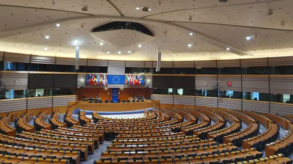 Brüksel 'deki Avrupa Parlamentosu' nun boş, yarı aydınlık genel kurulu (hemicycle). Tavanı görünen ziyaretçi galerisinden bir görüntü. Aralık 2023.