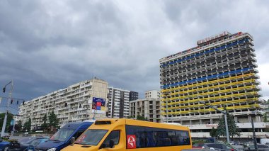 Moldova 'nın Kişinev kentinde bulunan Ulusal Otel' in (Hotelul National) kullanılmayan binası (Mayıs 2022). Ön cepheye resmedilme sürecinde Ukrayna bayrağının renkleri. Kara bulutlardan oluşan bir duvara karşı duran acımasız binalar..