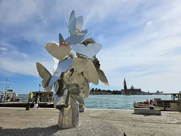 Venedik (Venezuela), İtalya, Mayıs 2024. Deniz kenarındaki modern soyut metal heykel. Ufukta San Giorgio Maggiore adası ve kilise görünüyor.. 