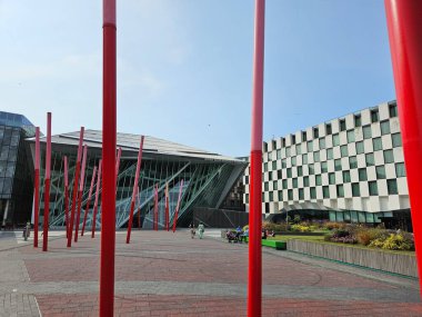 Dublin, İrlanda 'da Büyük Kanal Meydanı (Temmuz 2024). Kübik, modern tiyatro binasının arkasında parlak kırmızı direkler var.. 