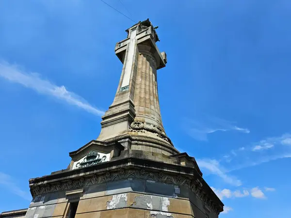 Monza, İtalya (Mayıs 2024): Expiatory Chapel (Cappella Espiatoria) dışında uzun taş haç. İtalya Kralı I. Umberto 'nun 1900' de suikasta kurban gitmesinin anısına yapılmıştır. Bir kurbağa gözünden çekilmiş..