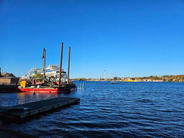 Stockholm, İsveç (Ekim 2024): Saltsjokvarn 'dan deniz manzarası. Şehir merkezindeki Saltsjon körfezinde koyu mavi su. Tekne limana yanaştı..