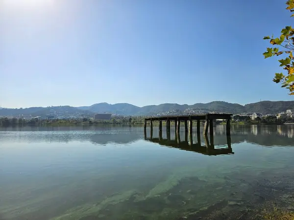 Tiran, Arnavutluk (Ekim 2024): Tiran Park 'taki yapay göl. Ufuktaki dağlara bakan ahşap yapı..