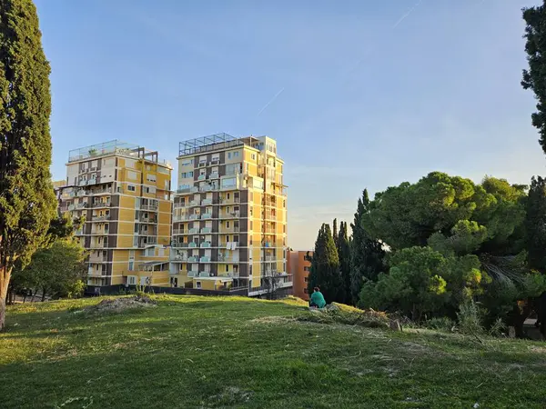 Durres, Arnavutluk (Ekim 2024): Kral 1. Zog Villa yakınlarındaki tepelerden gün batımı manzarası Güneş ışığıyla aydınlatılmış sarı kuleye bakan bir kadın..