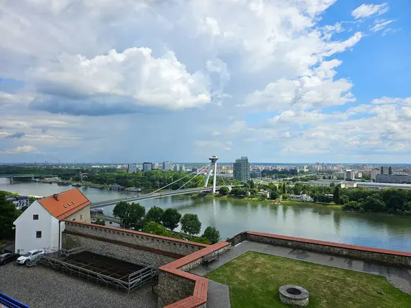 Bratislava, Slovakya (Mayıs 2025): Bratislava Kalesi 'nden görülen, UFO Köprüsü olarak da bilinen çoğu SNP köprüsü. Çekoslovak Komünist rejimi altında inşa edilen ve Tuna Nehri 'ni UFO şeklinde bir gözlem güvertesiyle geçen uzun bir köprünün havadan görünüşü..