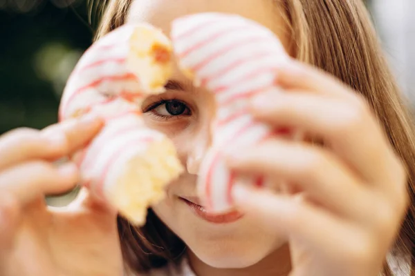 女孩拿着甜甜圈透过它看的画像 — 图库照片